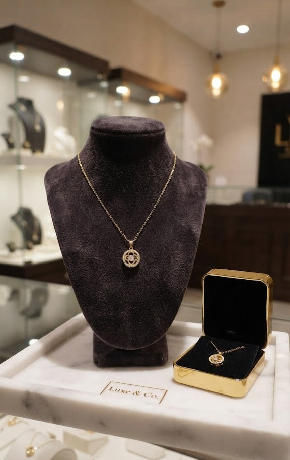 Close-up of gold CZ clover medallion pendant necklace on black velvet showing 18K gold-plated finish, clover motif and cubic zirconia sparkle – AureliaBlends Belle Fleur Collection