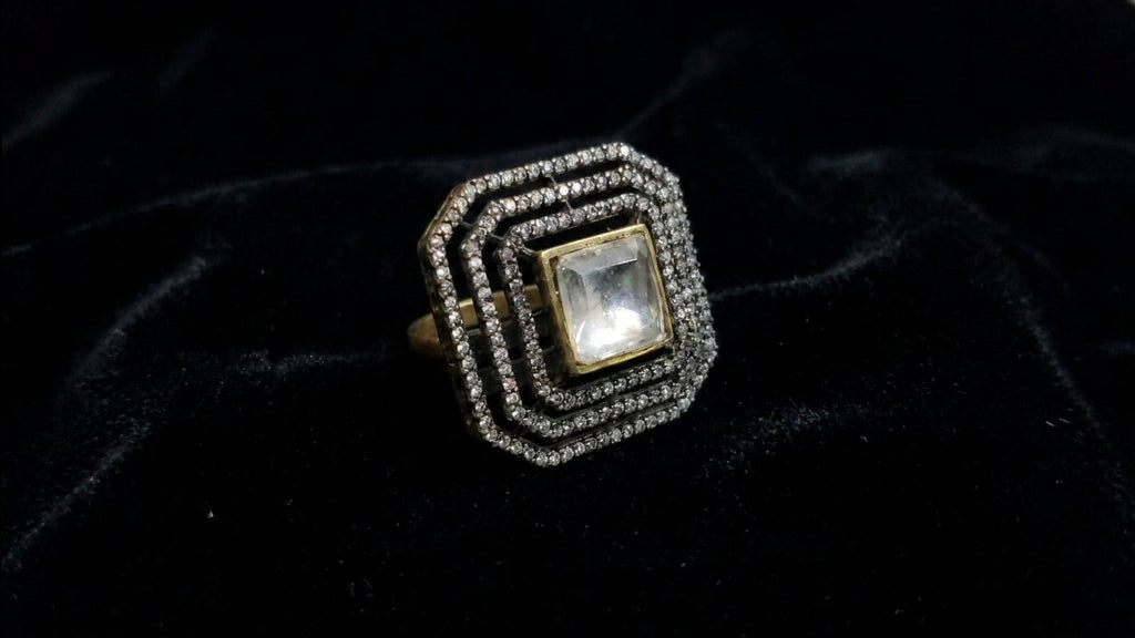 Crystal square CZ statement ring on black velvet showing Art Deco geometric halo setting and gold band – AureliaBlends