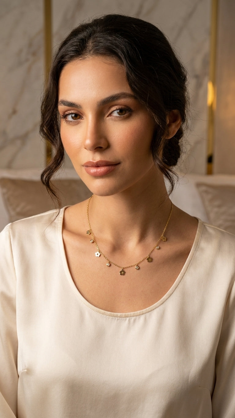 Gold flower charm necklace laid flat in green leather jewelry box on marble surface – gold-plated dangle necklace