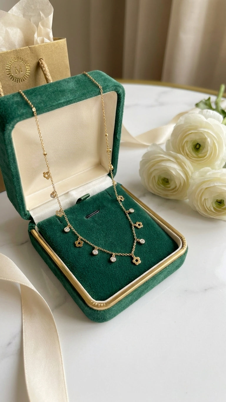 Woman wearing gold flower charm necklace with cubic zirconia drops on a delicate cable chain – bridal statement necklace