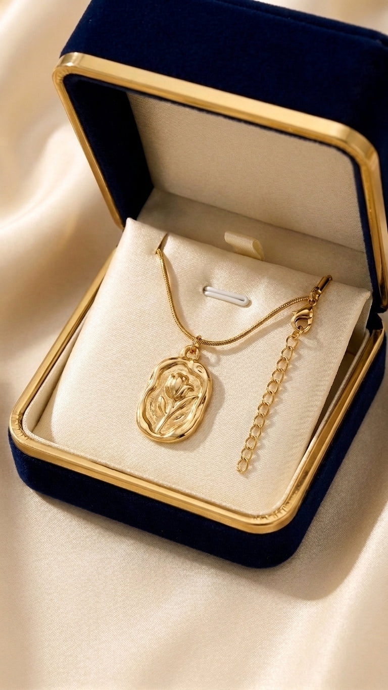 Gold tulip engraved locket pendant necklace on snake chain displayed on jewelry bust in luxury boutique setting – bridal jewelry AureliaBlends