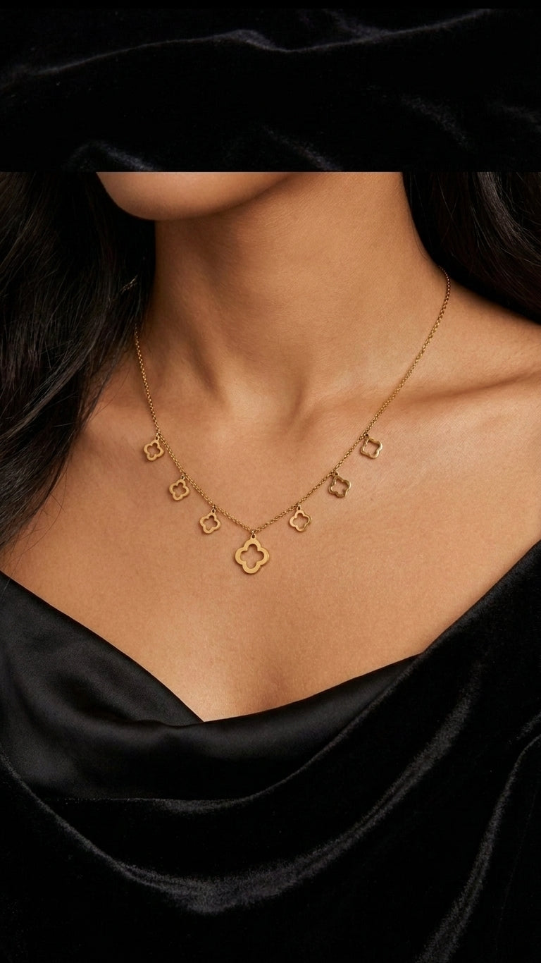 Gold open clover charm necklace and earrings set flatlay on cream satin with eucalyptus – four leaf clover necklace gold gift for her USA Australia