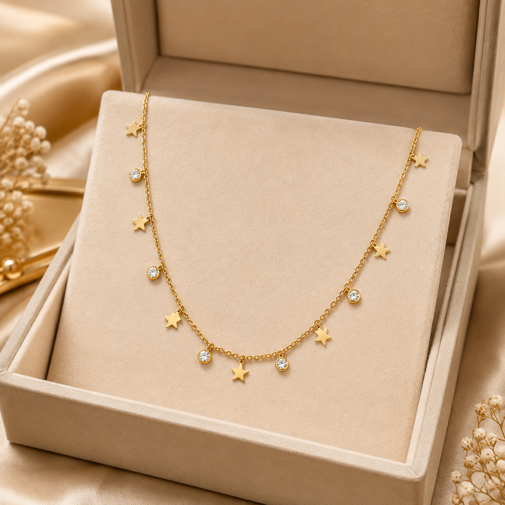 Gold alternating star charm and CZ crystal drop necklace on black velvet jewelry bust in dark luxury boutique setting with crystal glassware – statement necklace AureliaBlends