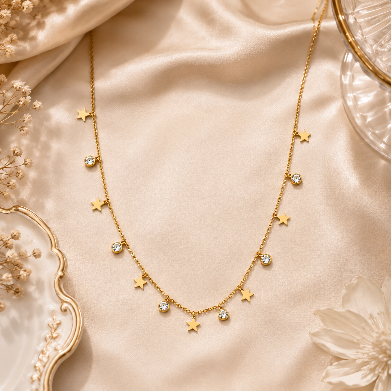 Gold star charm and cubic zirconia crystal dangle necklace on black velvet bust with teal jewellery box, pink and purple roses – formal occasion evening wear jewelry UAE