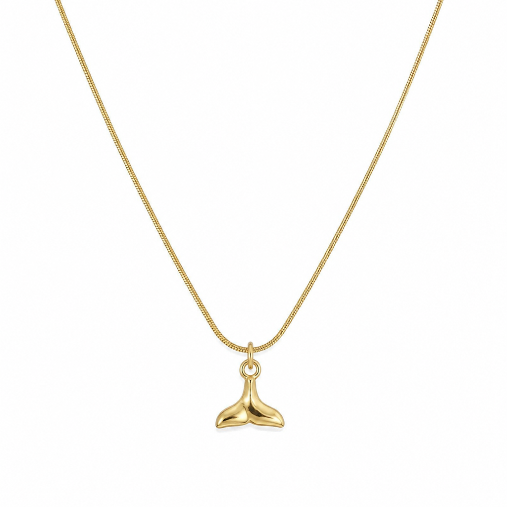 Woman wearing gold sculptural whale tail mermaid pendant necklace on slim box chain at collarbone in white v-neck top – dainty gold ocean necklace AureliaBlends
