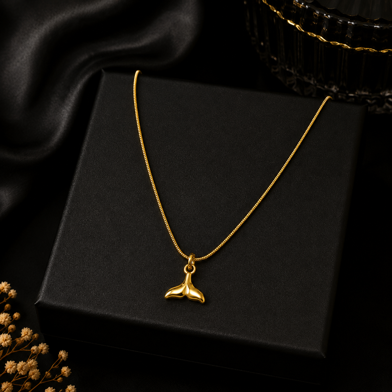 Gold whale tail mermaid pendant necklace displayed on black velvet jewelry bust in luxury jewellery boutique with 'Timeless Elegance' branding card and candlelight – wedding guest necklace USA UK