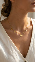 Gold multi-butterfly charm necklace and earrings set in open beige velvet gift box with locket surrounded by blush and cream roses, baby's breath and satin bow – bridal shower gift UK UAE