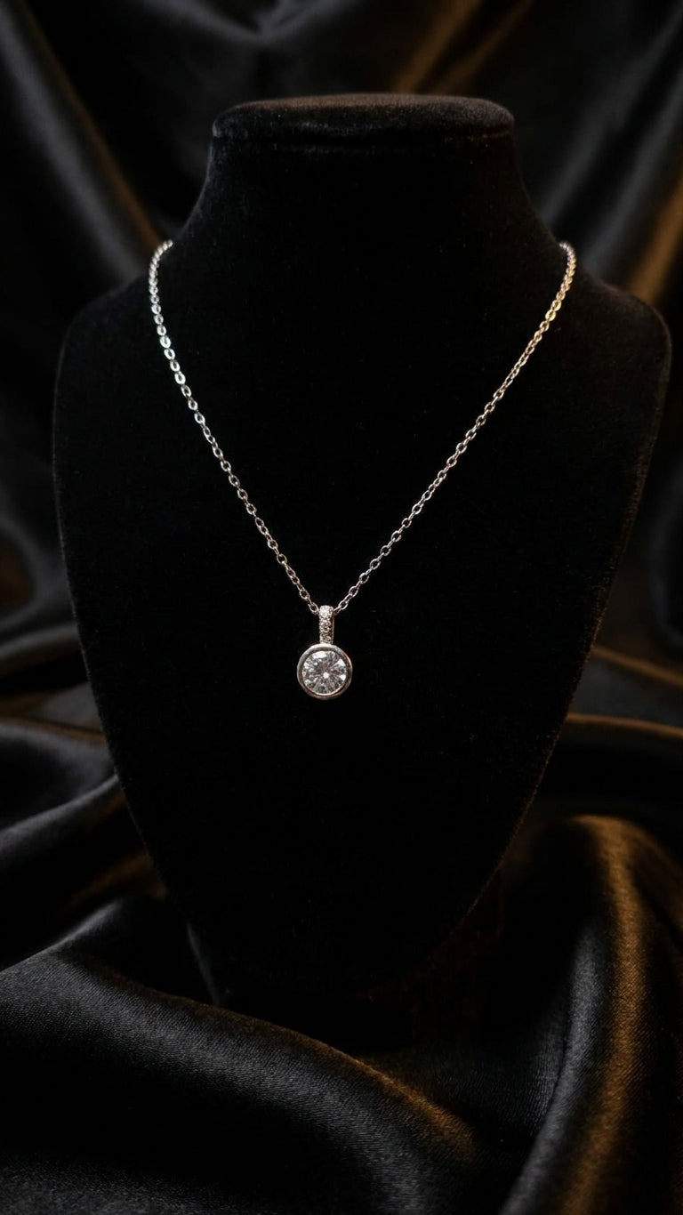 Silver round CZ solitaire pendant necklace displayed on black velvet jewelry bust in luxury jewellery boutique with glass display cases and white roses – formal occasion necklace USA UK Australia