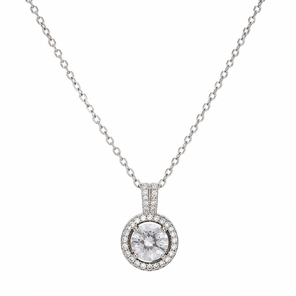 Silver round CZ halo pendant necklace with pavé surround and double-bar bail on fine cable chain flatlay on cream satin with crystal dish and dried baby's breath – diamond halo necklace AureliaBlends
