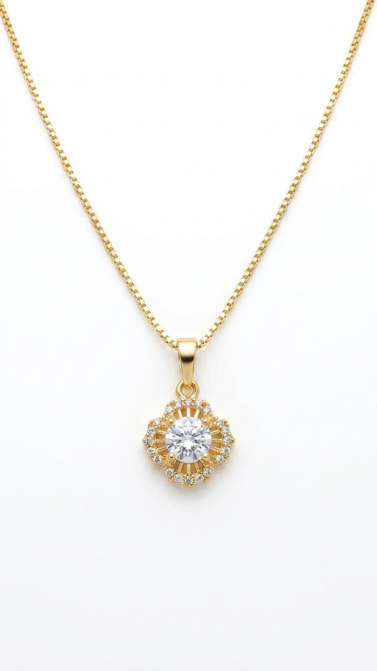 Woman wearing gold vintage floral sunburst CZ halo pendant necklace on slim box chain at collarbone in cream v-neck satin top against warm beige background – bridal jewelry AureliaBlends