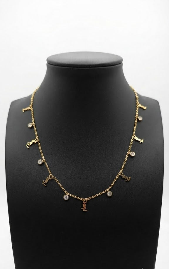 Dainty gold CZ station charm necklace on black velvet jewelry bust surrounded by colourful florals and agate slices – gold charm necklace by AureliaBlends