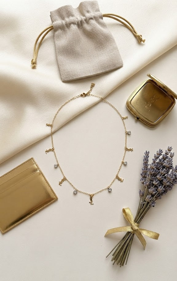 Model wearing dainty gold CZ station charm necklace over white silk slip dress – everyday gold necklace by AureliaBlends