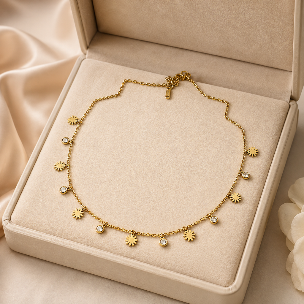Gold daisy CZ charm necklace on black velvet bust surrounded by pink roses and candlelight – bridal jewellery gift by AureliaBlends