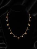 Gold daisy flower and cubic zirconia drop necklace laid flat on champagne satin fabric – dainty floral charm necklace AureliaBlends