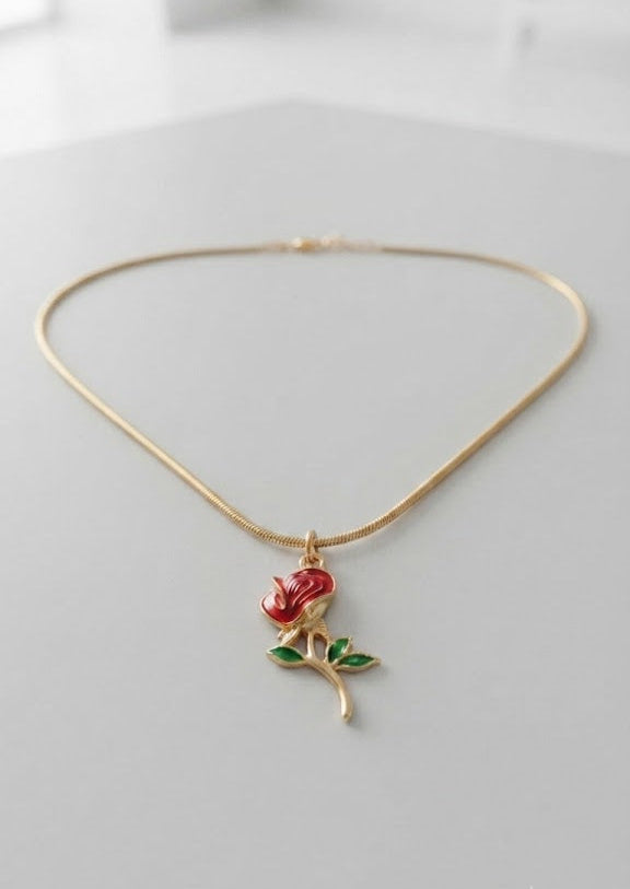 Gold red rose enamel pendant necklace on snake chain laid flat on white surface – dainty romantic necklace gift for her AureliaBlends