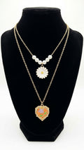 Gold double-layer pearl daisy pendant and orange enamel floral heart locket necklace set flat lay on cream satin with loose pearls and gold jewellery dish – romantic layered necklace gift by AureliaBlends