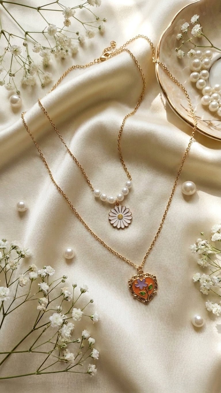 Gold double-layer pearl daisy pendant and floral heart locket necklace set flat lay on natural linen fabric – cottagecore layered necklace gift for her AureliaBlends