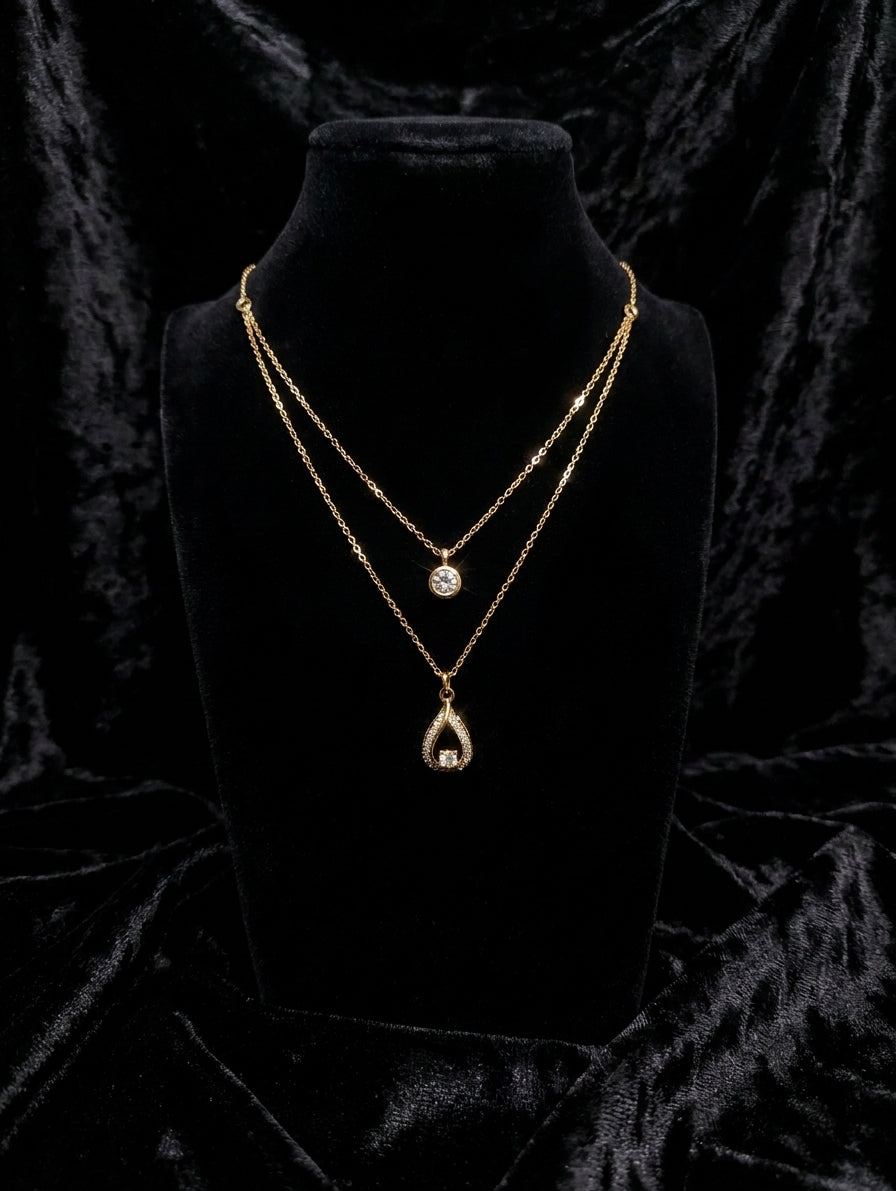 Gold double layer CZ solitaire and teardrop pendant necklace displayed in open wooden green velvet luxury jewelry box on wooden table – AureliaBlends