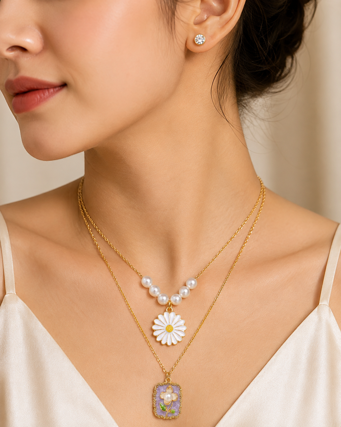 Gold pearl daisy and lavender floral rectangle pendant layered necklace set with CZ earrings flat lay on blush pink satin surrounded by pink roses and baby’s breath – floral jewellery gift for her AureliaBlends