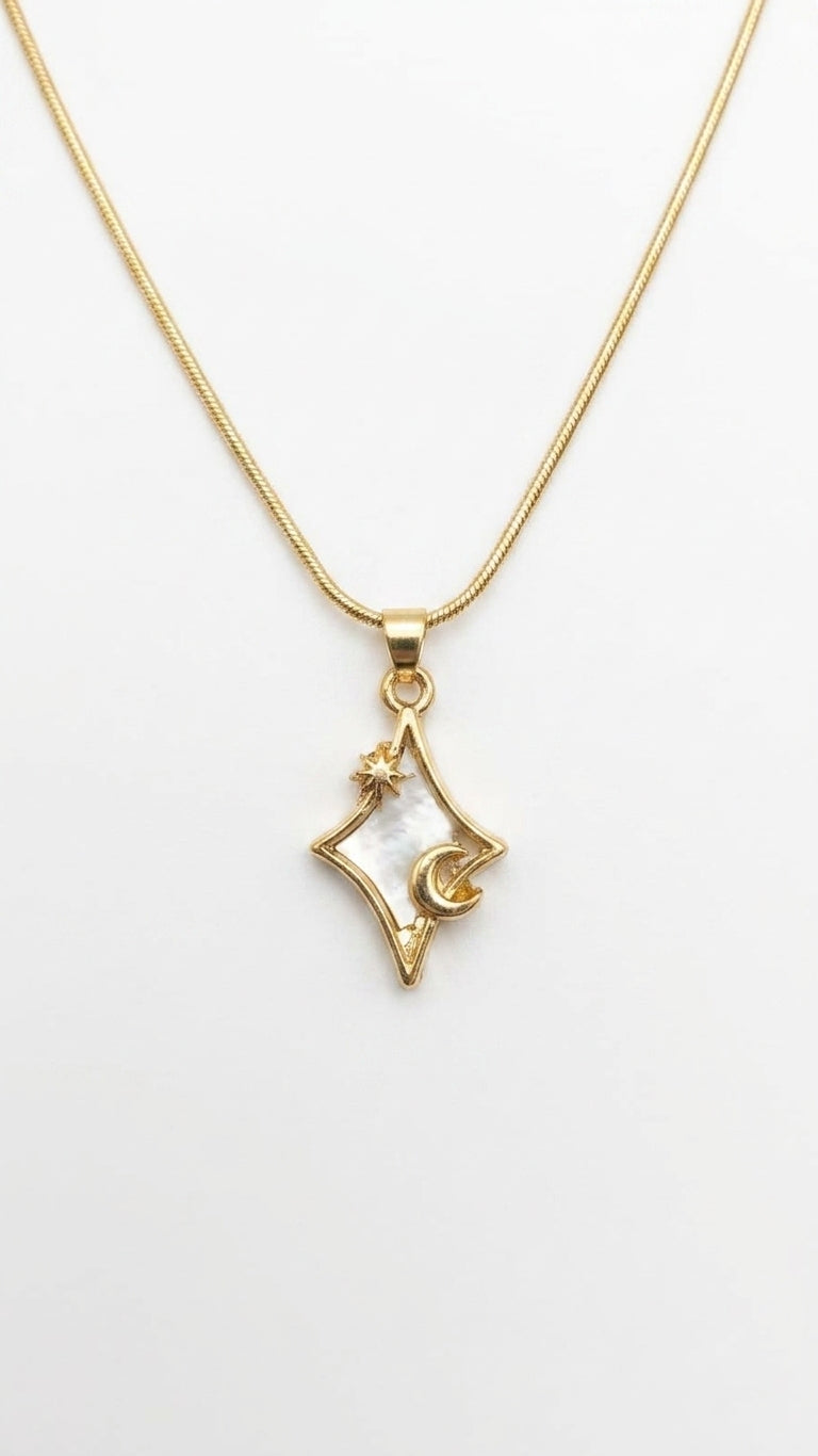 Gold four-pointed star and crescent moon mother of pearl pendant necklace flat lay on cream satin with dried botanicals, loose pearls and gold perfume bottle – celestial gold necklace by AureliaBlends