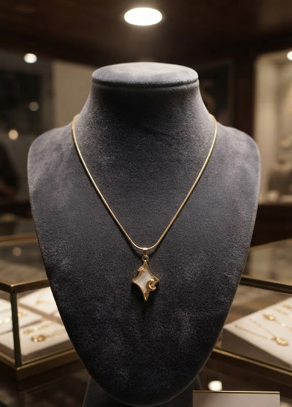Gold star and moon mother of pearl pendant necklace flat lay on cream satin with gold botanicals, dried flowers and gold perfume bottle – dainty celestial gold necklace AureliaBlends