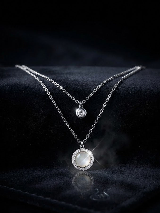 Silver double layer CZ solitaire and moonstone halo pendant necklace displayed in open navy blue velvet luxury jewelry box with gold hardware on beige background – AureliaBlends