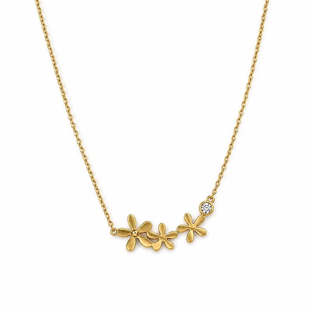 Gold triple daisy flower and CZ crystal pendant necklace flat lay on cream satin with baby’s breath and lace fabric – dainty 18K gold-plated floral necklace by AureliaBlends