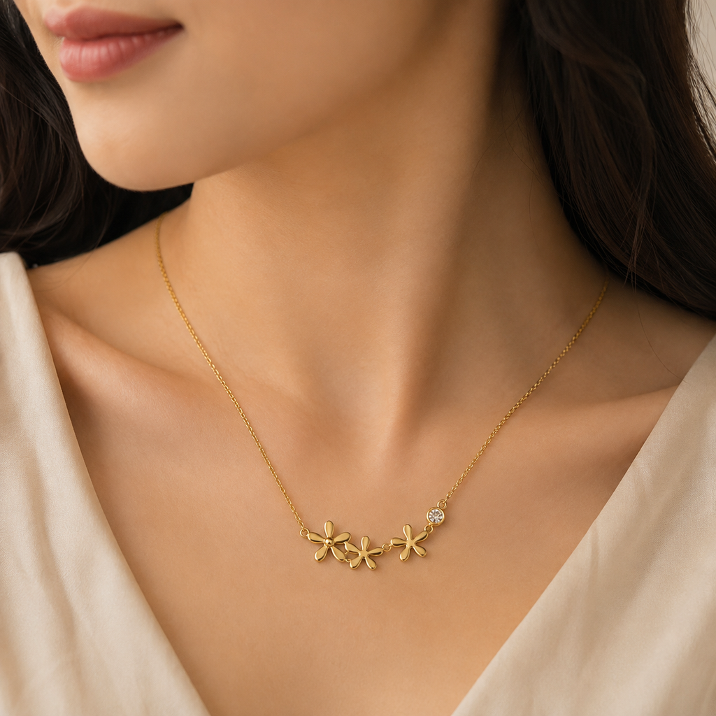 Gold triple daisy flower and CZ crystal pendant necklace flat lay on black satin with black ribbon and dried botanicals – luxury dainty gold daisy necklace AureliaBlends