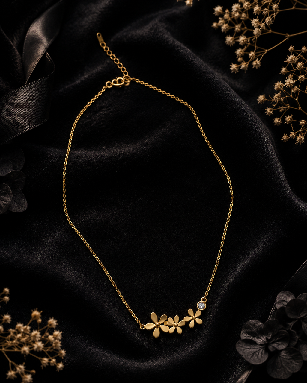 Gold triple daisy flower and CZ crystal pendant necklace flat lay on navy blue satin with jewel-toned silk, crystal candle holder, pink hydrangeas and emerald gift box – UAE luxury floral necklace AureliaBlends
