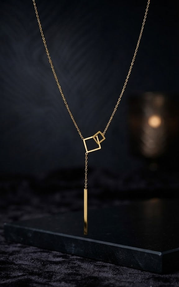 Close-up of gold double interlocking open square frames and bar drop pendant on delicate gold cable chain – 18K gold-plated geometric lariat Y-necklace detail by AureliaBlends