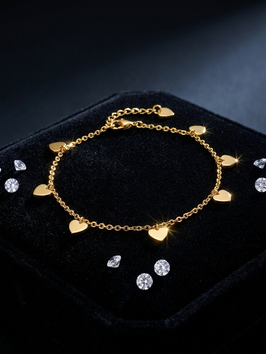 Gold-plated multi solid heart charm bracelet displayed on black velvet jewelry box with loose diamonds – AureliaBlends