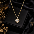 Gold heart halo CZ diamond solitaire pendant necklace flat lay on cream surface with dried botanicals and gold accessories – dainty diamond-look heart pendant necklace gift for her AureliaBlends