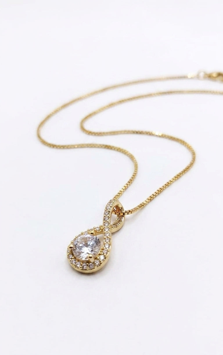 Woman wearing gold CZ infinity teardrop pendant necklace with vintage editorial styling – AureliaBlends Forever Yours collection