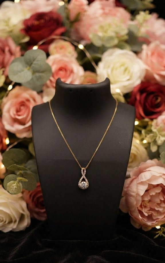 Gold CZ infinity teardrop pendant necklace product flat lay on neutral background showing full box chain and pendant detail – AureliaBlends