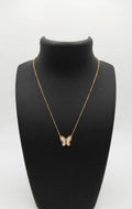 Woman wearing dainty gold butterfly mother of pearl necklace with black silk top – AureliaBlends butterfly pendant necklace