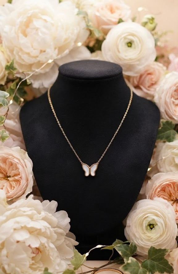 Gold butterfly mother of pearl necklace close-up showing shell inlay pendant on fine gold cable chain