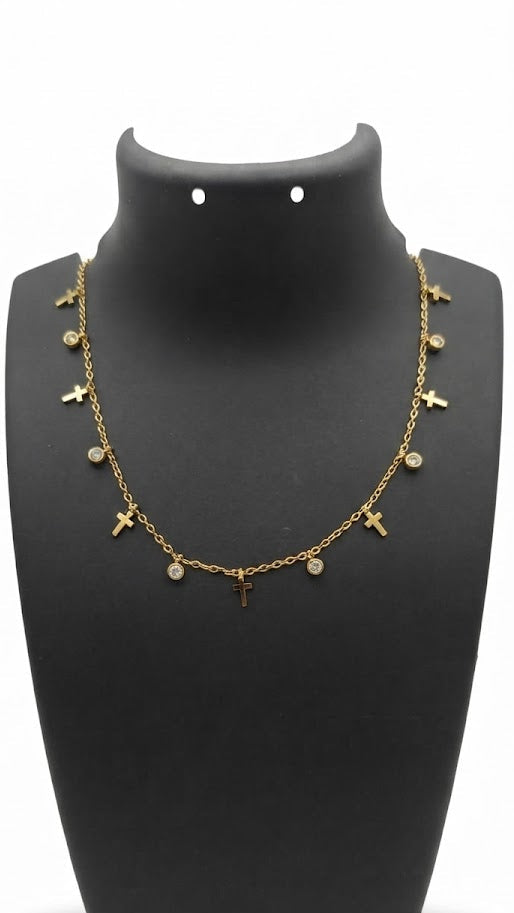 Gold cross charm necklace with cubic zirconia crystal accents displayed on black jewelry bust against white background
