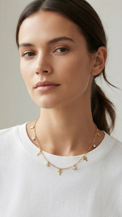 Woman wearing gold cross charm and crystal necklace styled with white t-shirt – AureliaBlends dainty cross pendant necklace