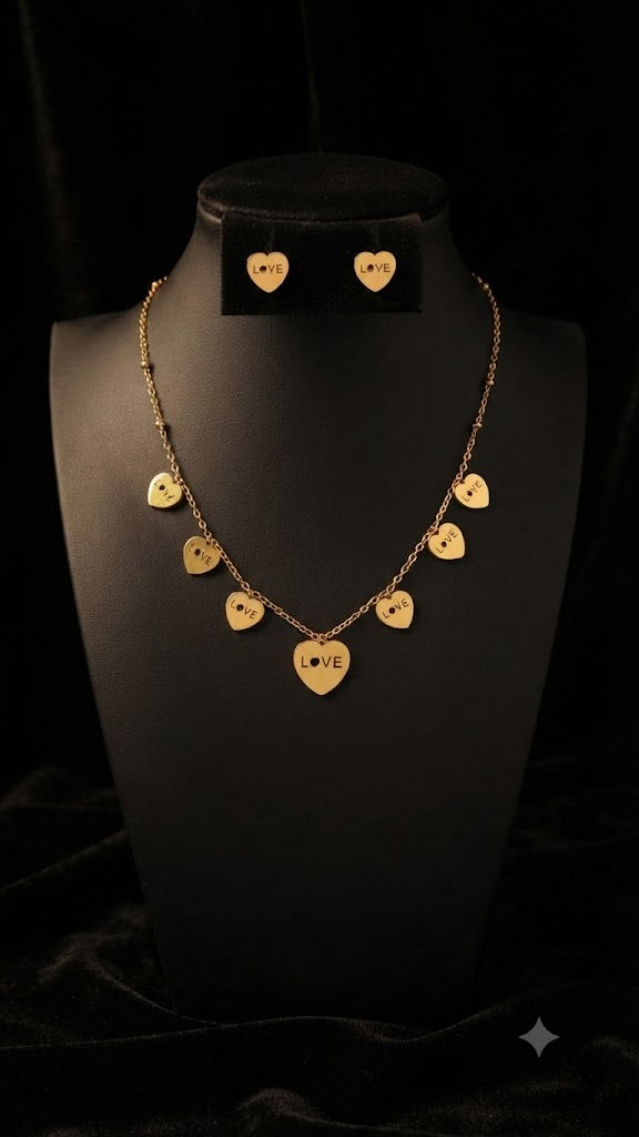 Gold love heart charm necklace and earrings set displayed in jewelry store window with The Golden Heart nameplate