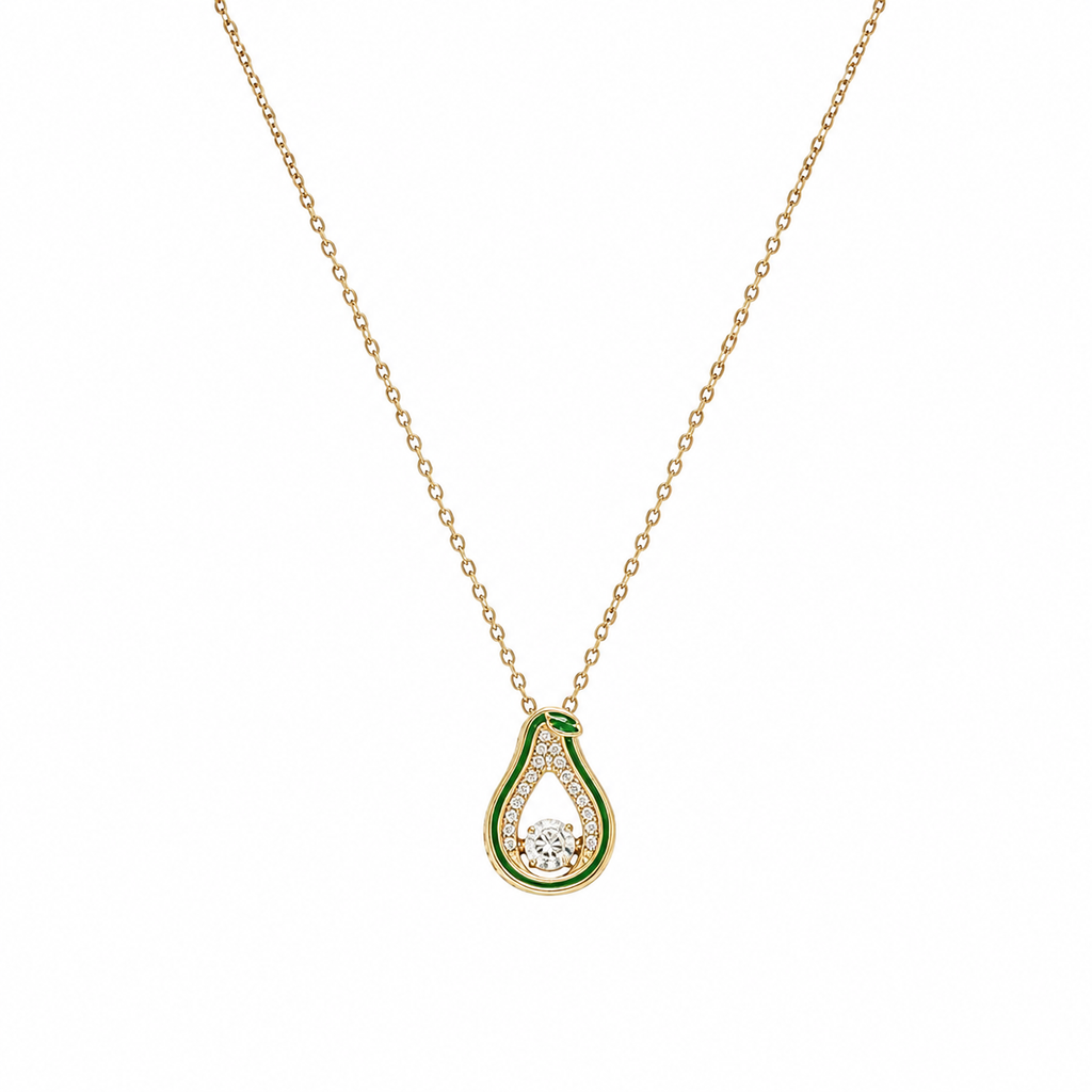 Woman wearing gold green enamel teardrop CZ pendant necklace with cream V-neck silk dress in warm interior setting – AureliaBlends Jade Pear Collection lifestyle shot