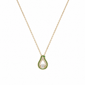 Woman wearing gold green enamel teardrop CZ pendant necklace with cream V-neck silk dress in warm interior setting – AureliaBlends Jade Pear Collection lifestyle shot