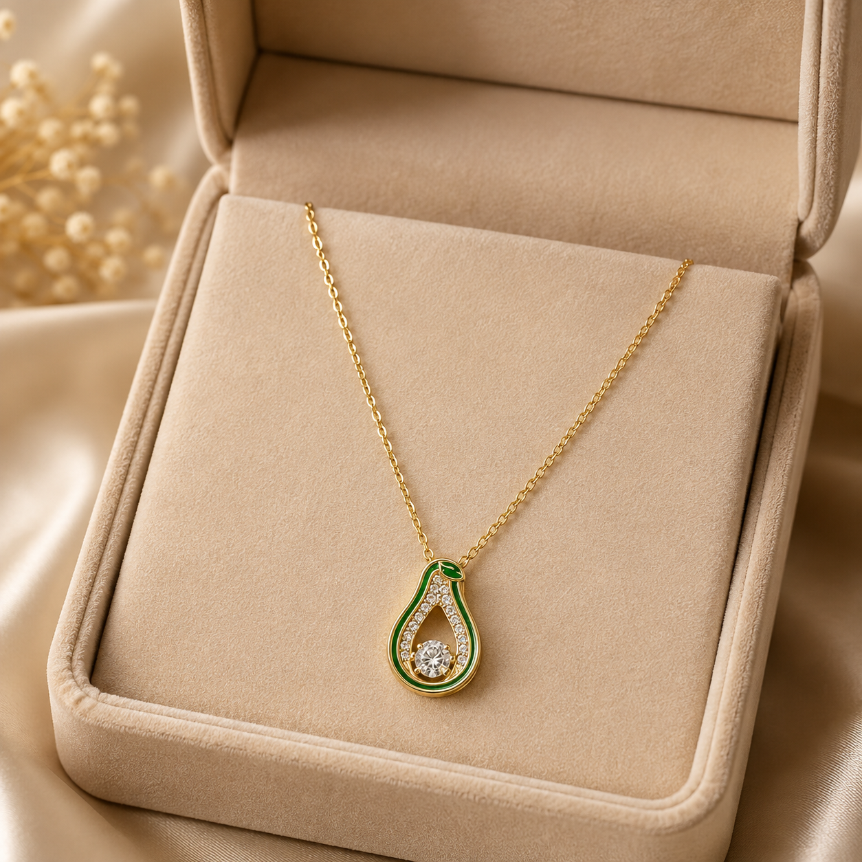 Gold green enamel teardrop CZ pendant necklace on cream satin fabric with dried baby's breath flowers – AureliaBlends dangle pendant necklace flat lay