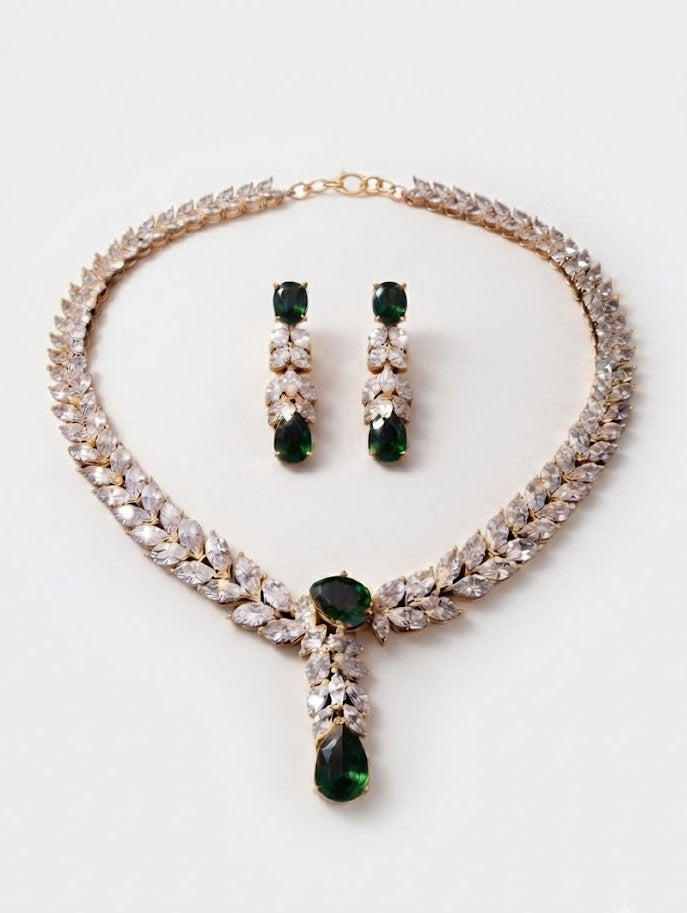 Emerald green CZ leaf necklace and drop earrings set flat lay on white background – AureliaBlends