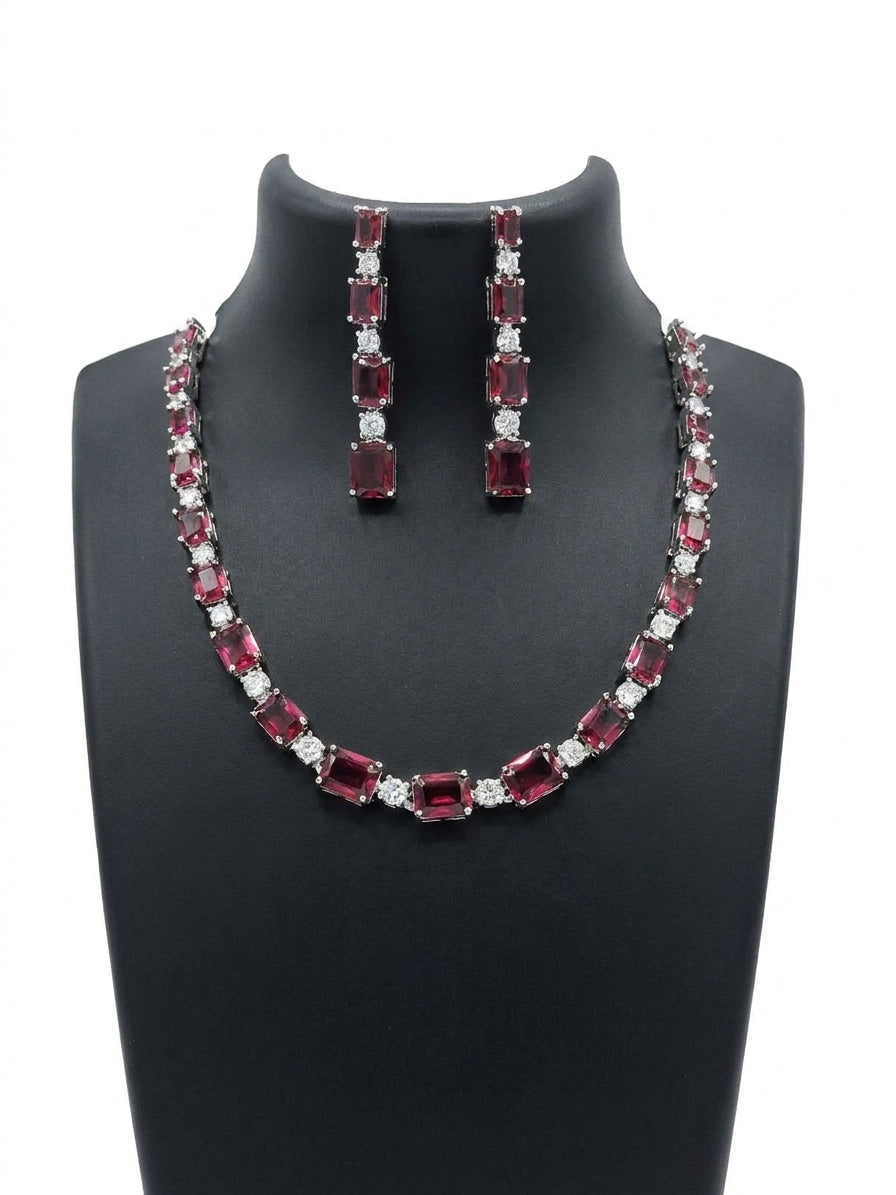 Ruby red emerald cut CZ tennis necklace and long drop earrings bridal set on black jewelry bust on white background – AureliaBlends