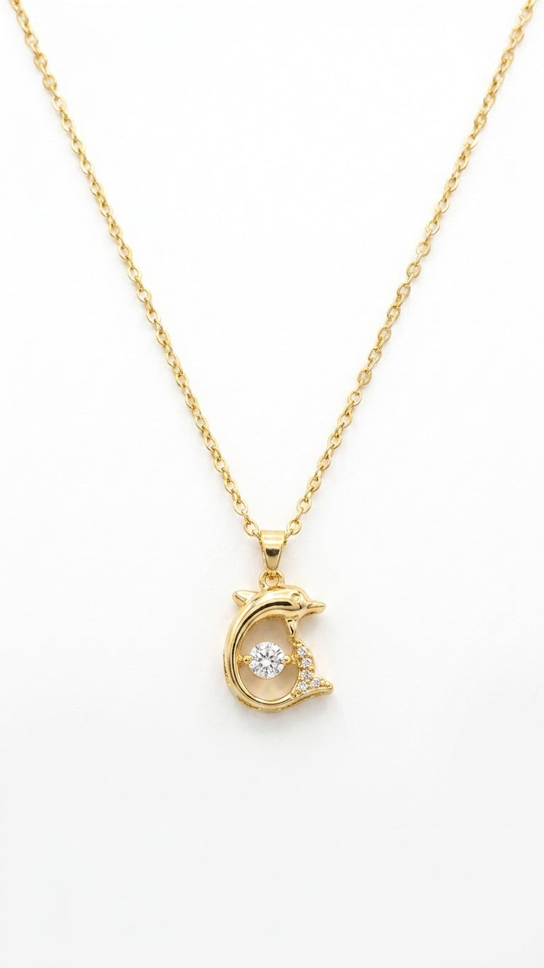 Gold CZ dolphin pendant necklace on cream satin flat lay with teal velvet gift box, vintage gold hand mirror and white orchids – AureliaBlends Ocean Soul Collection