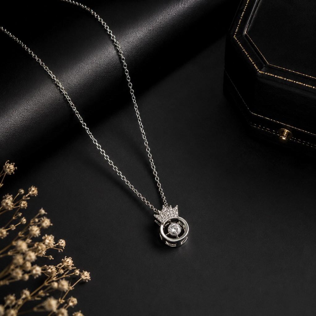 Silver CZ crown orbital pendant necklace on champagne velvet cushion in gold gift box with purple satin lining, pink roses, hydrangeas and amber candle – AureliaBlends UAE luxury jewelry