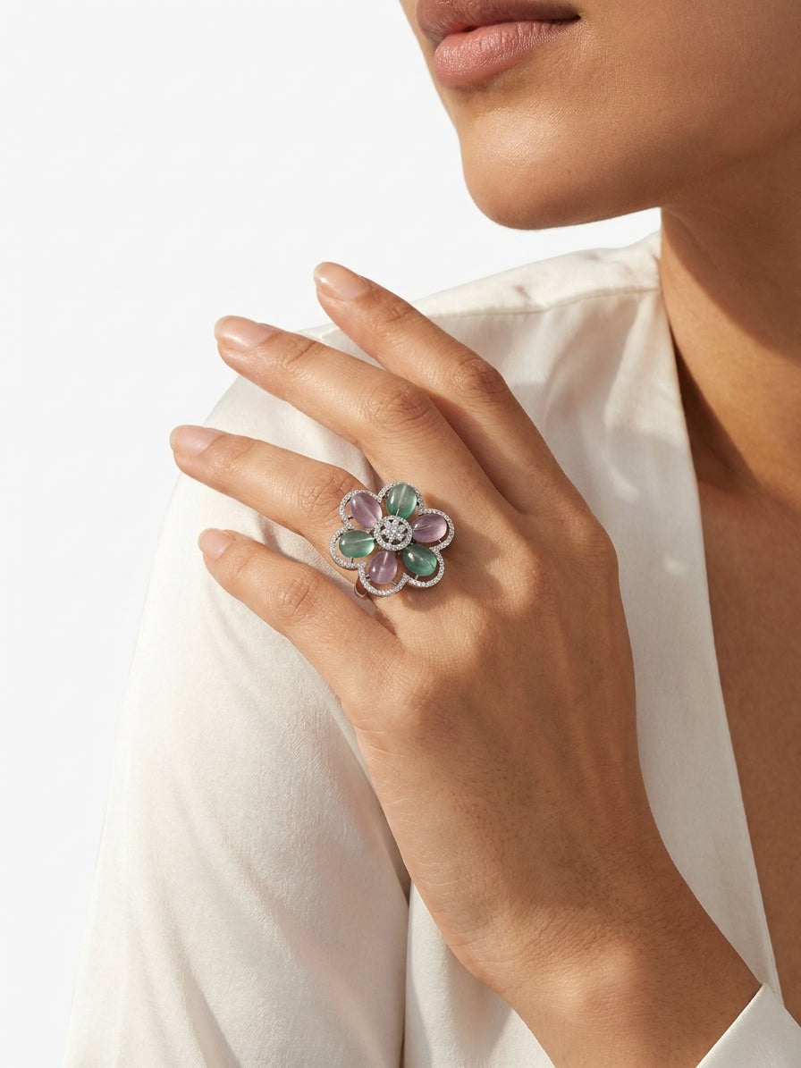 Woman wearing yellow cat-eye stone floral cocktail statement ring in rose gold CZ setting on index finger with neutral manicure holding navy blue velvet ring box – AureliaBlends