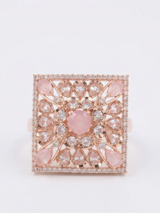 Rose gold square filigree statement cocktail ring with pink opal cabochons and CZ pavé border displayed on black velvet ring cushion on dark marble surface with sparkle effect – AureliaBlends