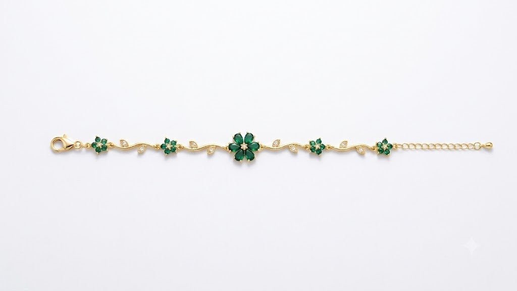 Woman wearing gold-plated emerald green CZ floral vine statement bracelet on wrist in white blazer – AureliaBlends