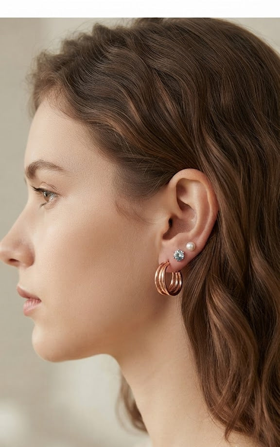 Rose gold triple hoop earrings with pearl and blue crystal studs on black velvet surrounded by pink roses – AureliaBlends luxury earring set